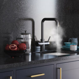 a gun metal d-neck tap running steaming hot water in a modern kitchen
